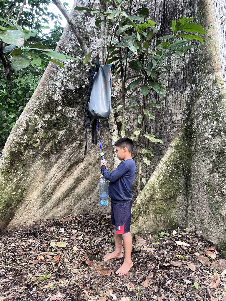 Criança indígena pega água em kit de filtro e armazenamento de água da startup Água Camelo na Aldeia Mutum, no Acre - Divulgação